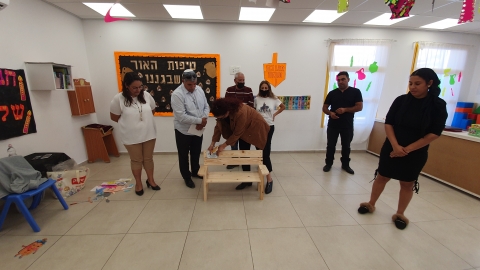 האמא שני מדביקה את השלט לזכרו של עדו זל.jpg